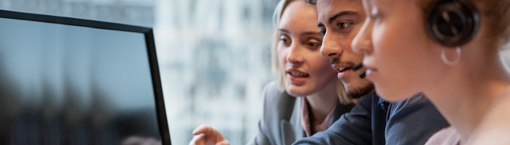 En mann og 2 damer ser på en pc-skjerm