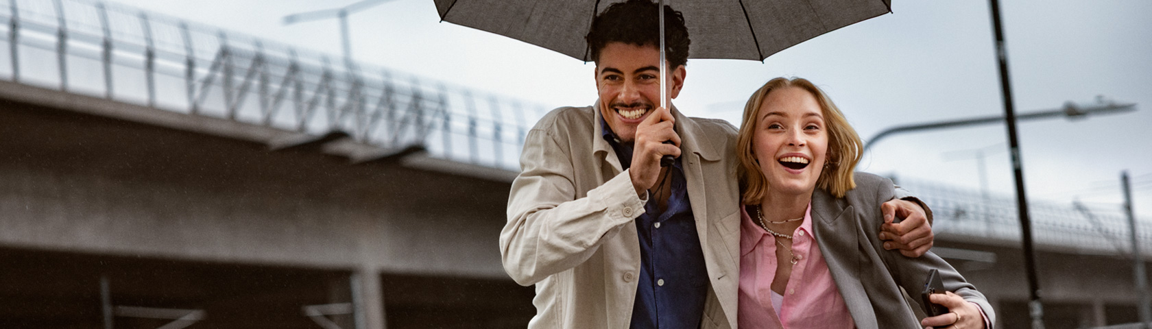 Mann og dame går sammen og holder en paraply