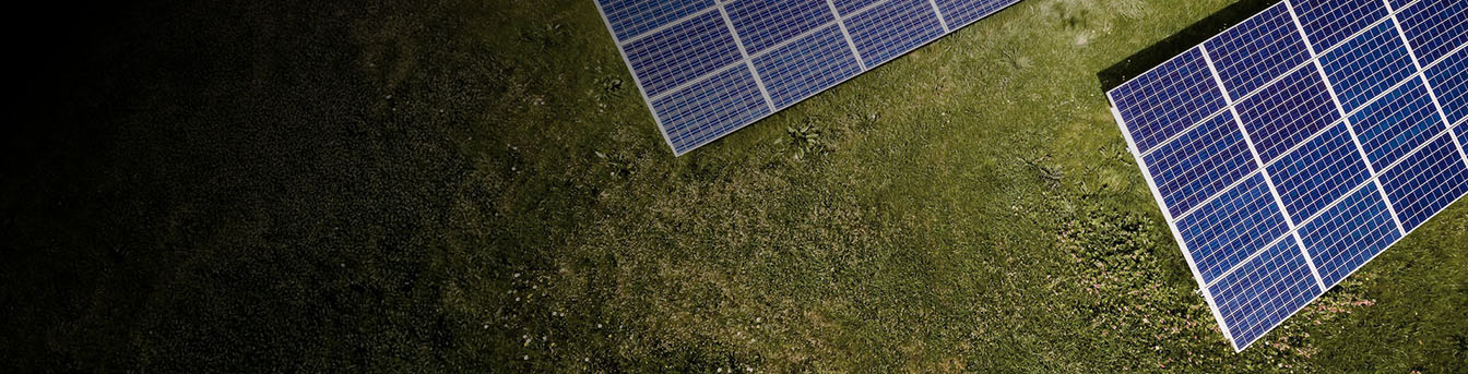 Område dekket med gress og solceller, sett ovenfra.
