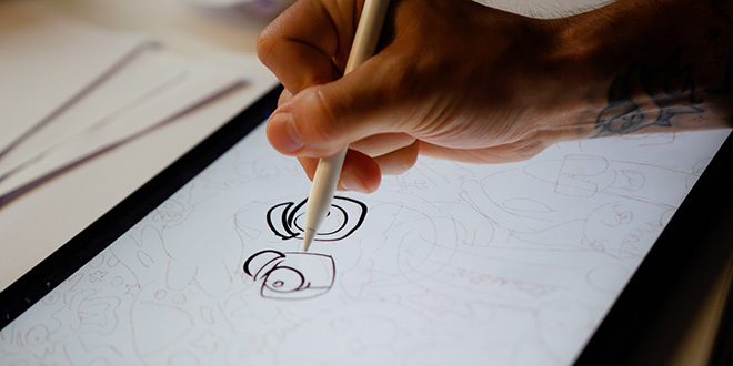 Christopher Robin Omdahl is sketching away at the drawing board. Christopher Robin Omdahl is sketching away at the drawing board.