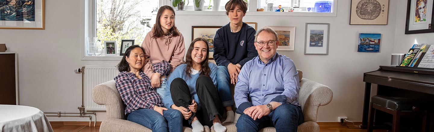 Familie på fem sitter i sofaen.